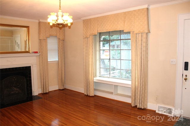 unfurnished living room with crown molding, a notable chandelier, a tiled fireplace, and dark hardwood / wood-style flooring