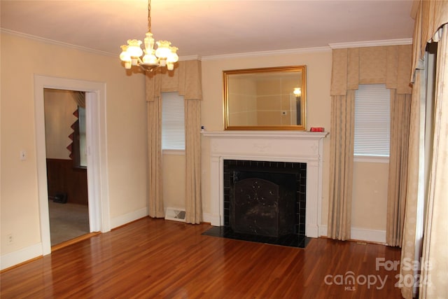 unfurnished living room featuring dark wood-type flooring, a notable chandelier, ornamental molding, and a tile fireplace