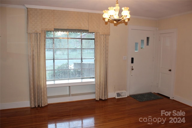 foyer entrance featuring ornamental molding, dark hardwood / wood-style floors, and an inviting chandelier