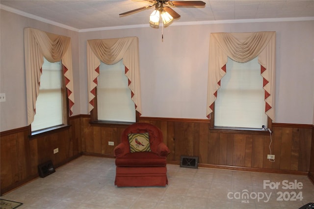 unfurnished room featuring crown molding, wood walls, and ceiling fan