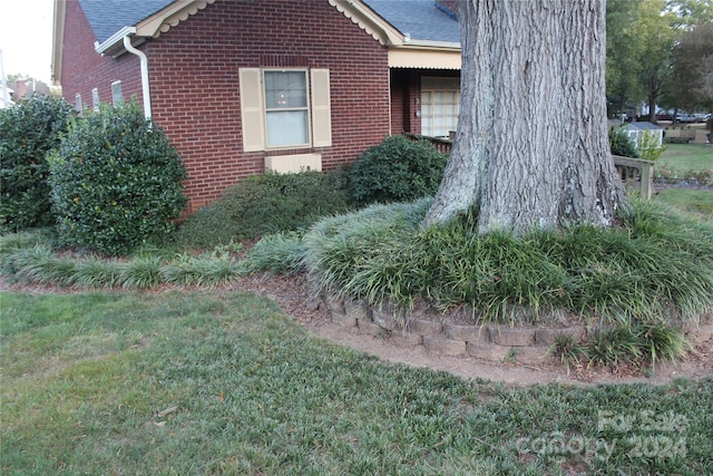 view of side of home with a yard