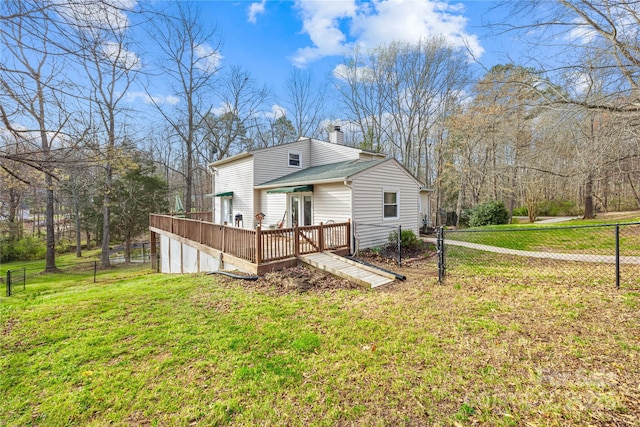 back of house featuring a wooden deck and a lawn