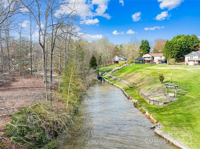 view of community with a yard and a water view