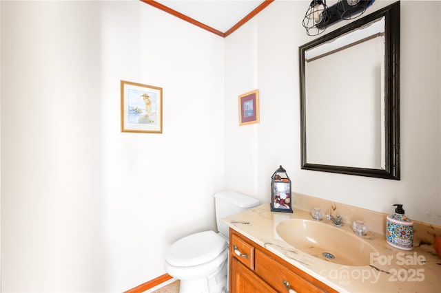 bathroom with vanity, crown molding, and toilet