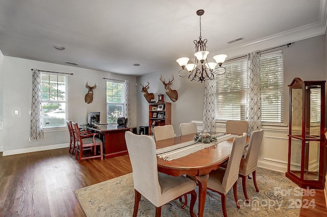 dining area with ornamental molding, dark hardwood / wood-style floors, and a chandelier