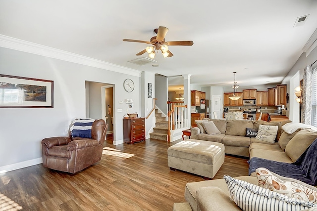 living room with hardwood / wood-style flooring, ceiling fan, crown molding, and decorative columns