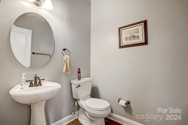 bathroom with hardwood / wood-style floors and toilet