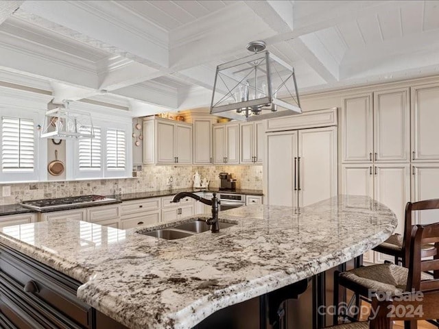 kitchen with a large island, sink, hanging light fixtures, and beamed ceiling