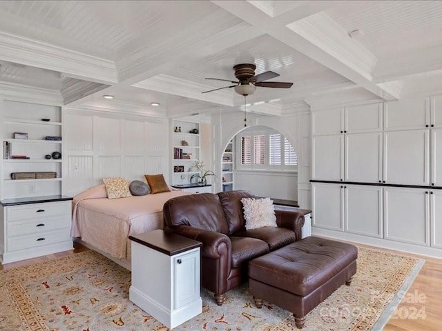 bedroom featuring coffered ceiling, beamed ceiling, ornamental molding, light hardwood / wood-style floors, and ceiling fan