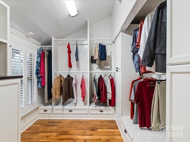 walk in closet with wood-type flooring and vaulted ceiling