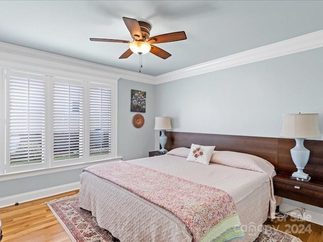 bedroom with ornamental molding, hardwood / wood-style floors, and ceiling fan