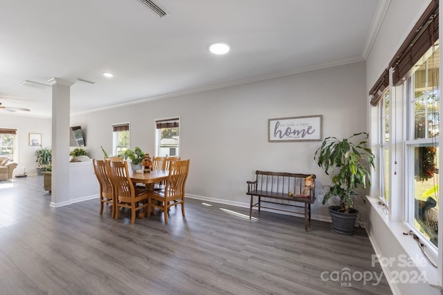 dining room with ceiling fan, wood-type flooring, crown molding, and decorative columns