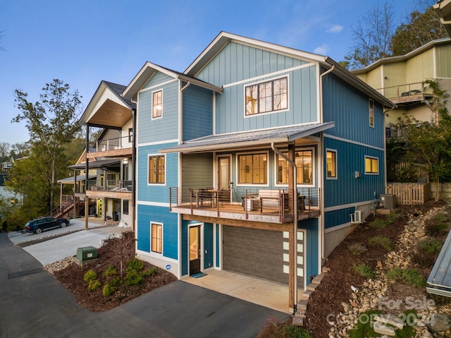 view of front facade with central AC unit, a garage, and a balcony