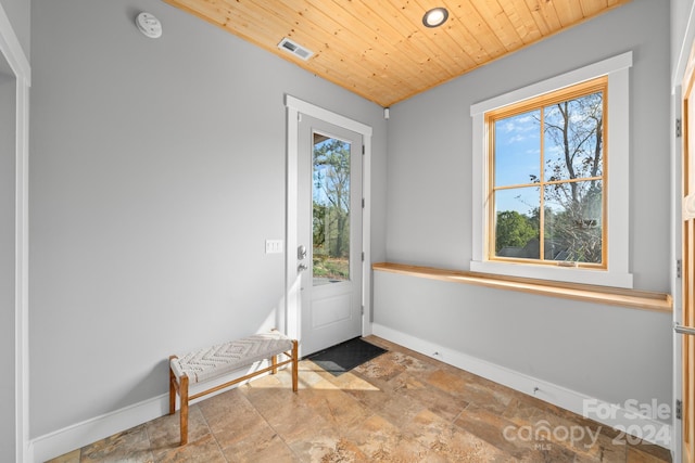 doorway to outside with wood ceiling and plenty of natural light