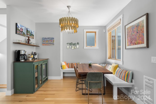 dining room with wood-type flooring and an inviting chandelier