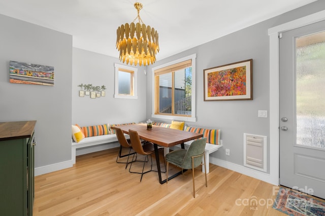 dining space with wood-type flooring and an inviting chandelier