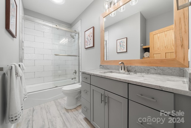 full bathroom featuring vanity, toilet, hardwood / wood-style flooring, and tiled shower / bath combo