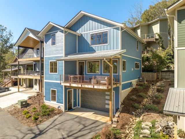 view of front of house with a balcony, central AC, and a garage