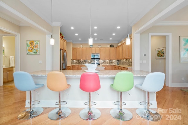 kitchen with light wood-type flooring, decorative light fixtures, backsplash, and stainless steel appliances