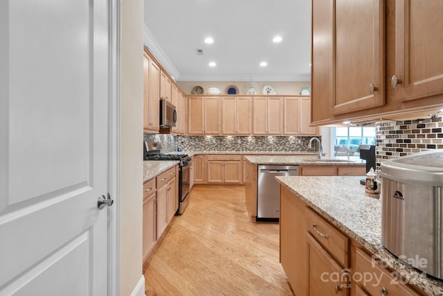 kitchen with sink, crown molding, light hardwood / wood-style flooring, light stone counters, and stainless steel appliances