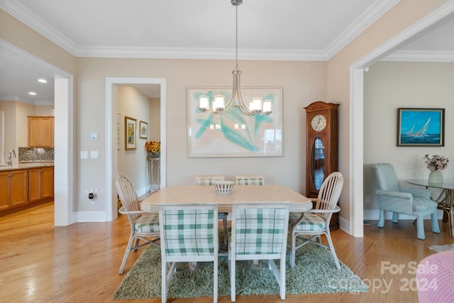 dining space featuring a notable chandelier, light hardwood / wood-style floors, and ornamental molding