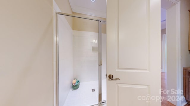 bathroom with hardwood / wood-style flooring and walk in shower