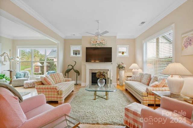 living room featuring light hardwood / wood-style flooring, ceiling fan, and ornamental molding