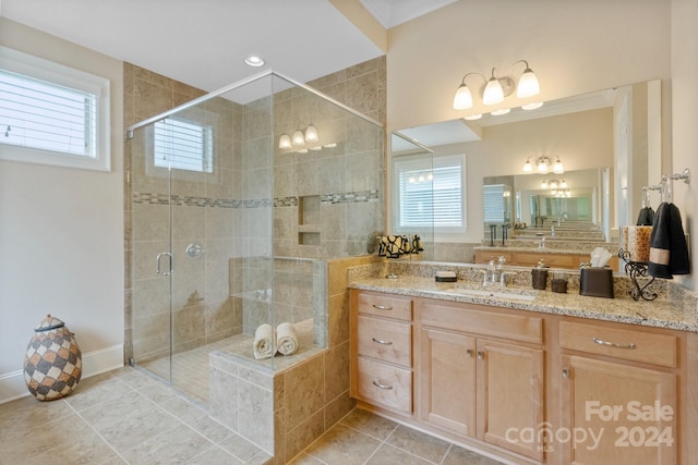 bathroom with tile patterned floors, a shower with door, vanity, and ornamental molding