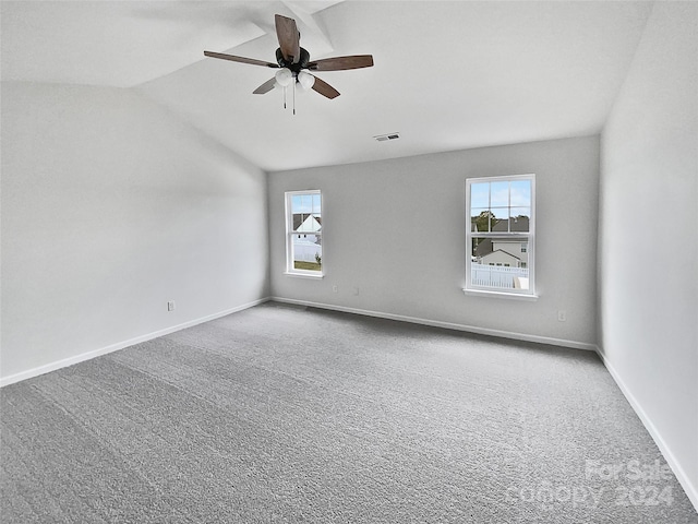 spare room featuring carpet floors, ceiling fan, and vaulted ceiling