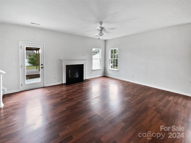 unfurnished living room with dark wood-type flooring and ceiling fan