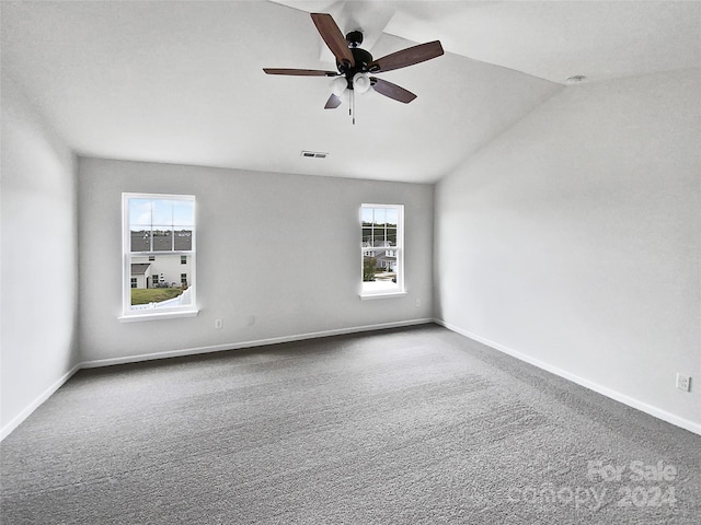 unfurnished room featuring vaulted ceiling, a wealth of natural light, carpet floors, and ceiling fan