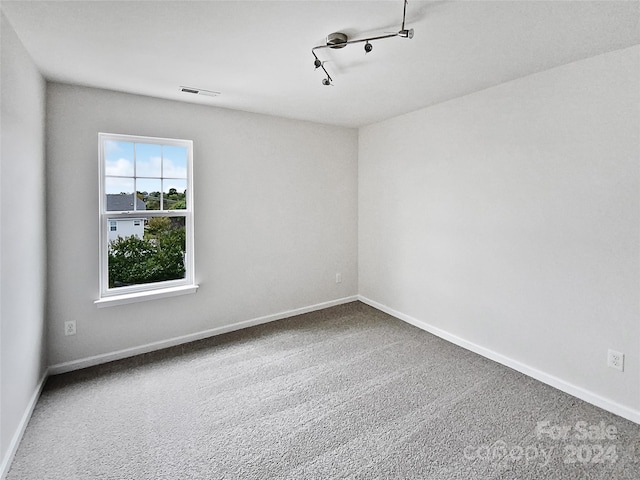 spare room with carpet and track lighting