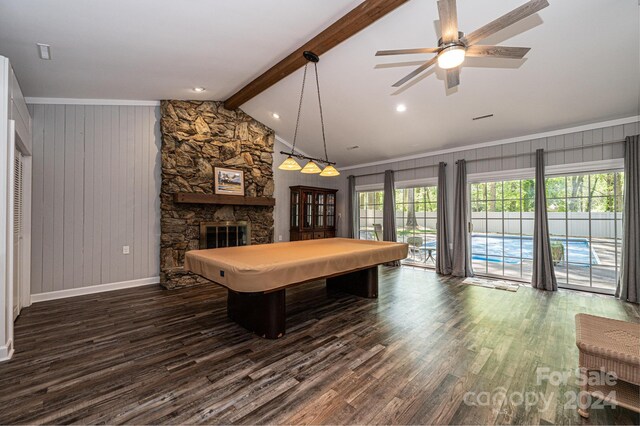 game room featuring lofted ceiling with beams, a stone fireplace, ceiling fan, dark wood-type flooring, and ornamental molding