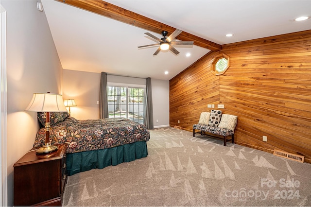 bedroom featuring wood walls, beamed ceiling, light colored carpet, and ceiling fan