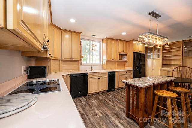 kitchen with black appliances, decorative light fixtures, dark hardwood / wood-style floors, and a breakfast bar