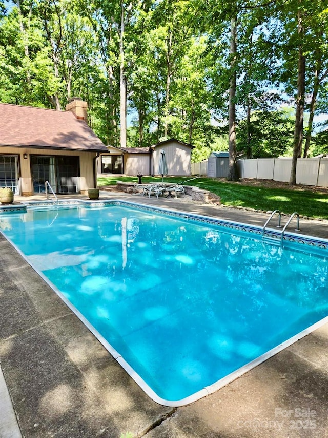 view of swimming pool featuring a storage shed