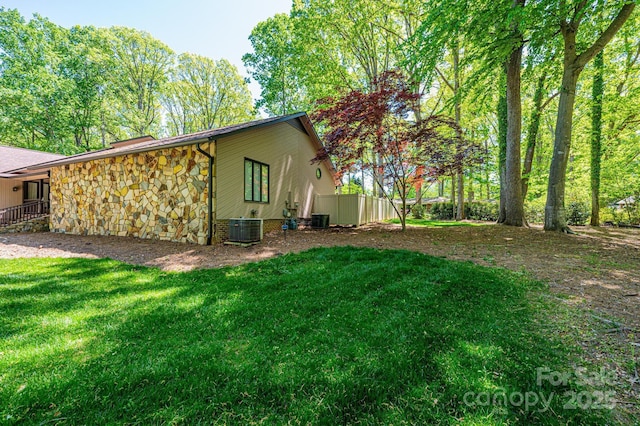 view of home's exterior featuring central AC unit and a lawn