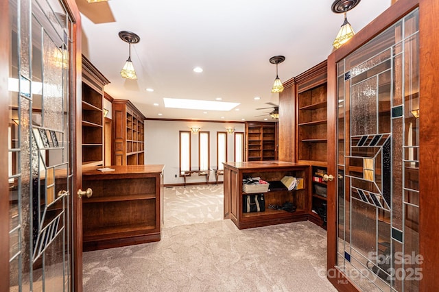 wine area with crown molding, light carpet, ceiling fan, and a skylight