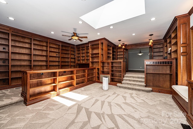 wine room with crown molding, ceiling fan, a skylight, and light carpet