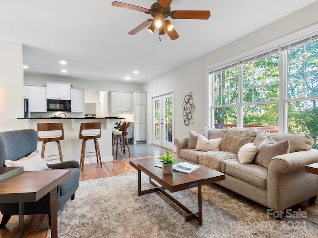 living room with hardwood / wood-style floors, ceiling fan, and french doors