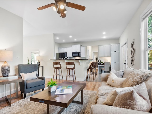 living room featuring ceiling fan and light wood-type flooring