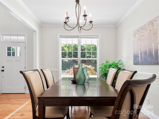 dining space featuring hardwood / wood-style floors, a notable chandelier, and ornamental molding