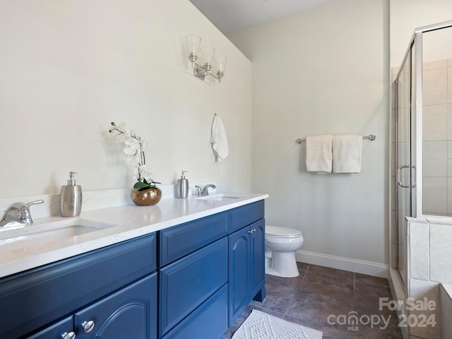 bathroom with toilet, vanity, and a shower with shower door