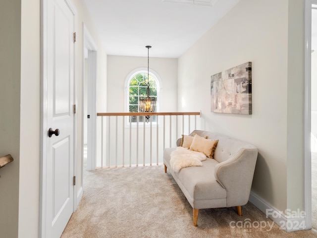 living area featuring a notable chandelier and light carpet