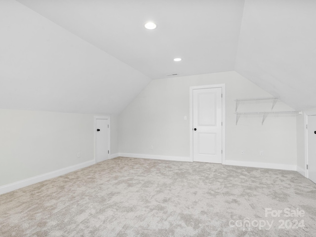 additional living space with vaulted ceiling and carpet floors