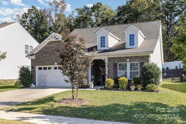 cape cod home with a garage and a front lawn