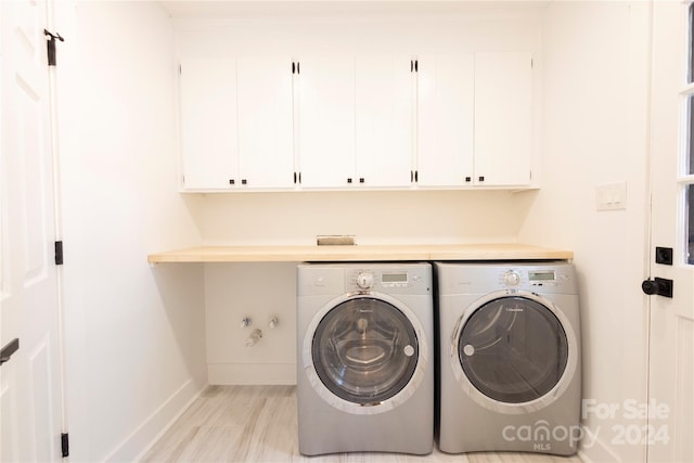 washroom with cabinets, light hardwood / wood-style flooring, and separate washer and dryer