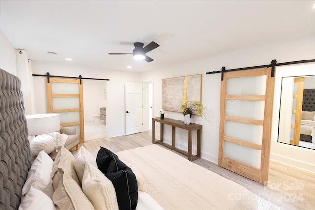 bedroom featuring ensuite bath, light hardwood / wood-style flooring, and ceiling fan