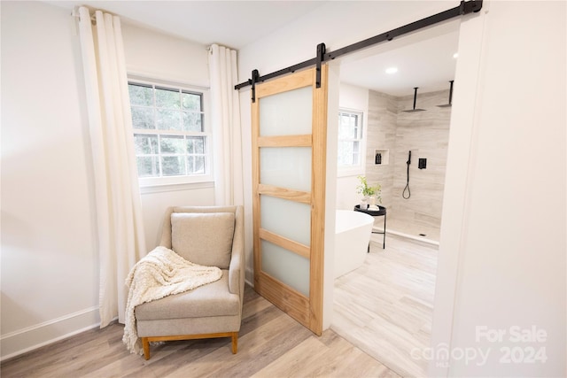 sitting room featuring light hardwood / wood-style flooring and a barn door