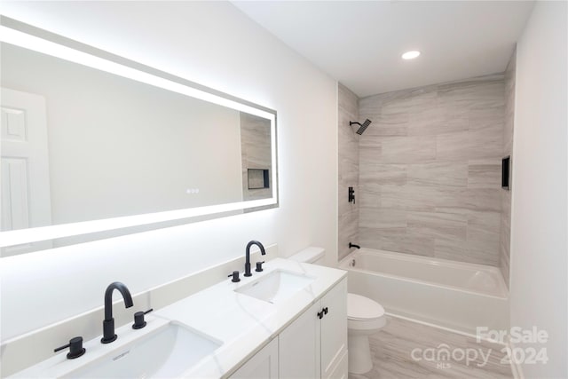 full bathroom featuring vanity, toilet, hardwood / wood-style flooring, and tiled shower / bath